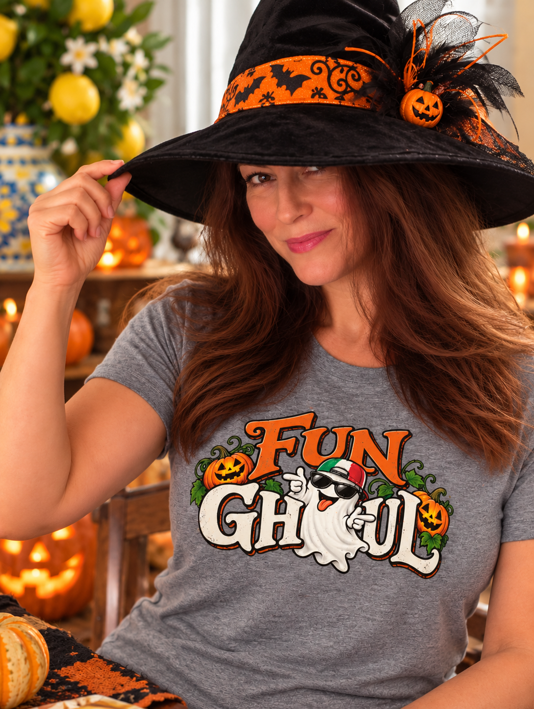 Woman wearing gray Fun Ghoul Halloween T-shirt featuring Italian ghost and pumpkins, paired with a witch hat. Funny Italian Halloween shirt.