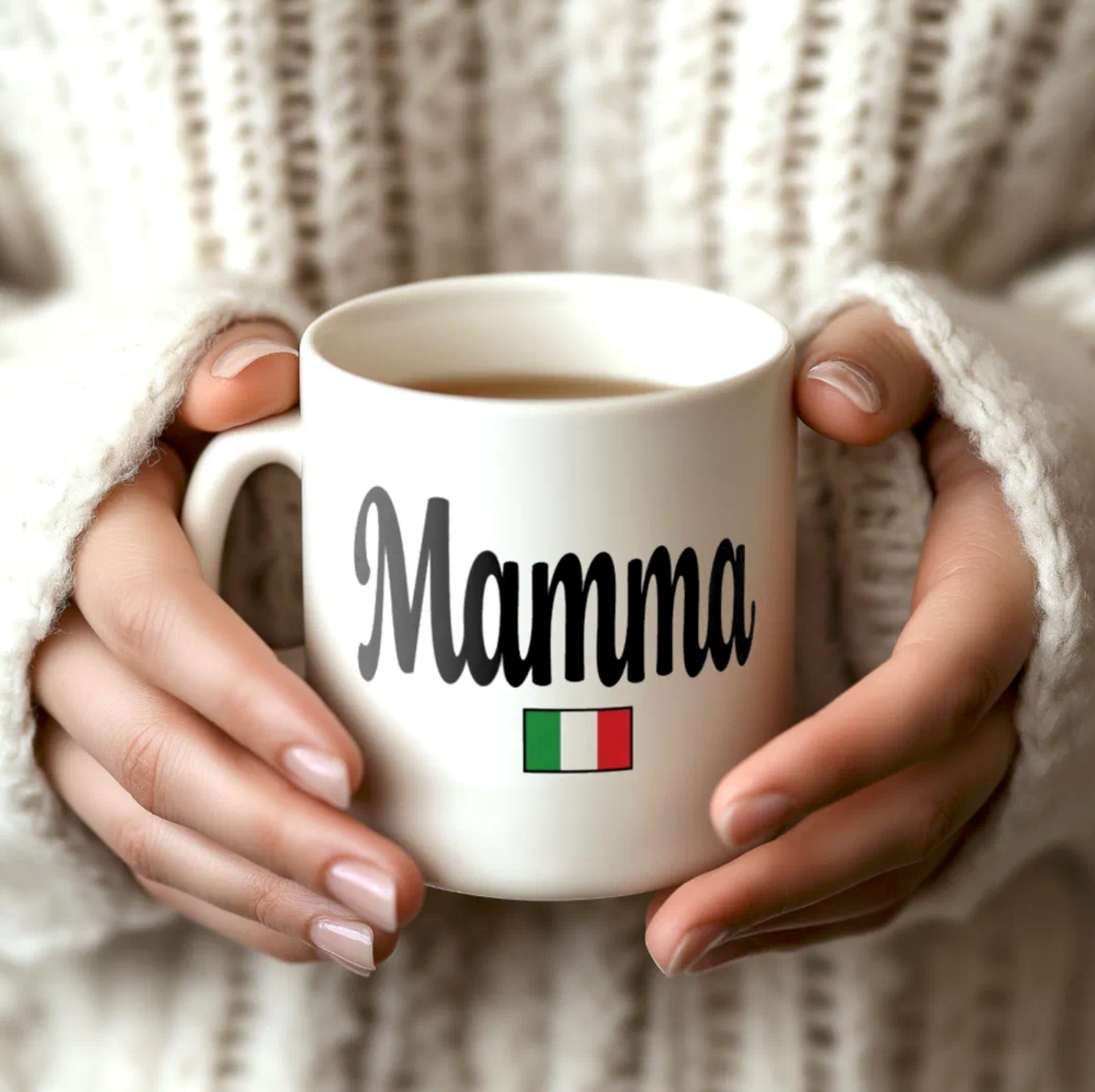White mug with 'Mamma' and Italian flag held by hands against a textured beige background
