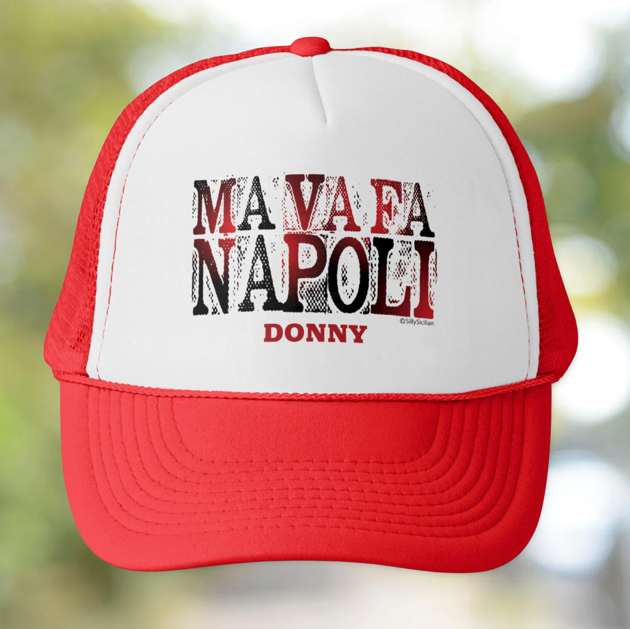 Red and white cap with 'MA VA FA NAPOLI DONNY' personalized text on a blurred natural background