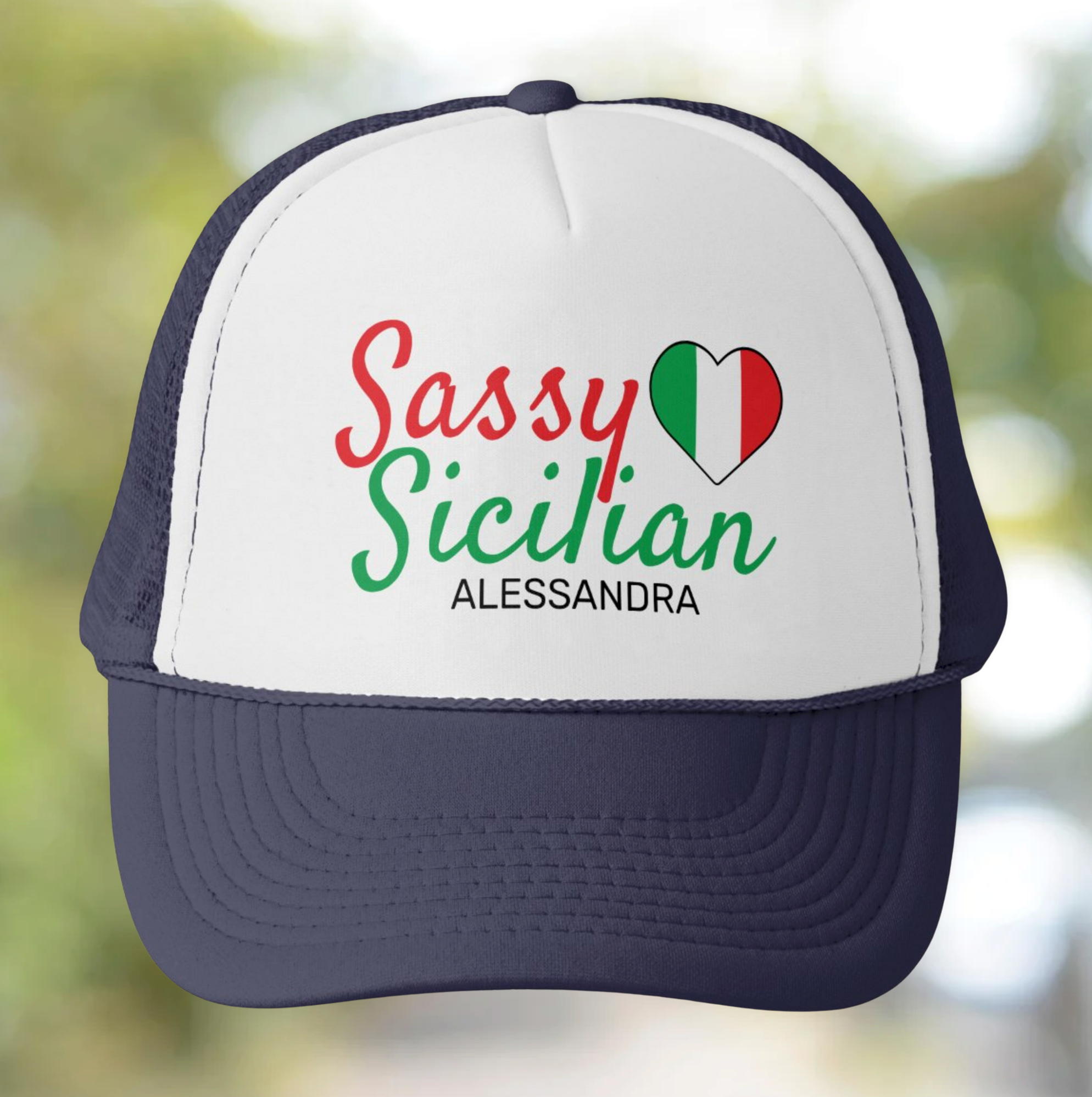 Trucker hat with 'Sassy Sicilian' personalized text and Italian flag design on a blurred natural background