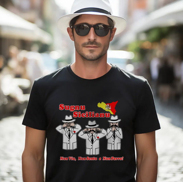 Man wearing a black t-shirt with a Sugnu Sicilianu funny graphic design and text, standing on a street.