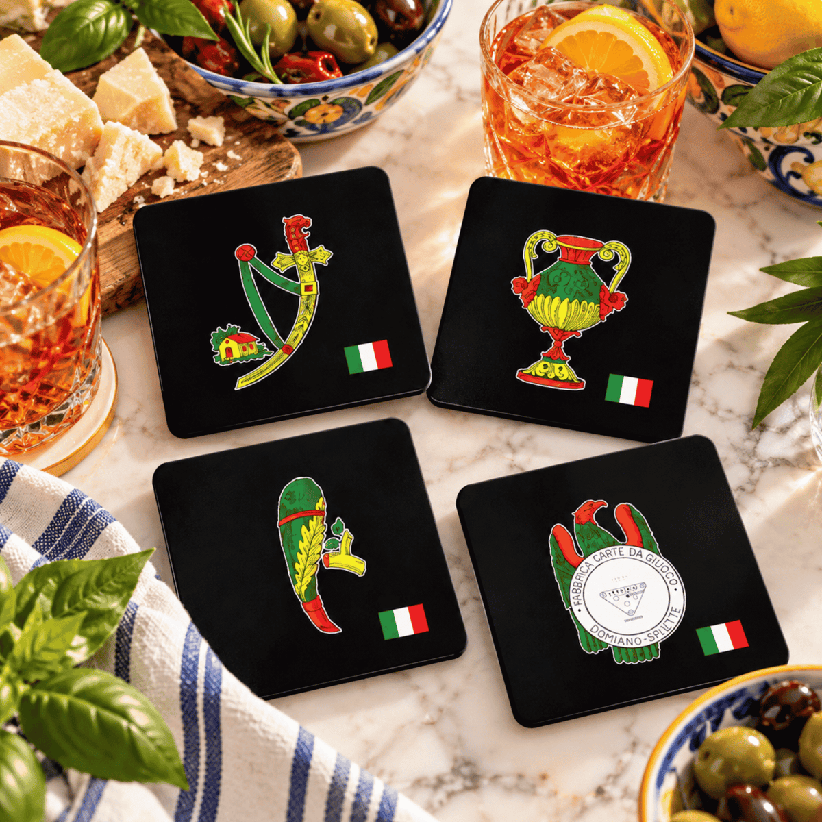 Italian heritage coaster set featuring vintage Italian artwork and Italian flag designs, displayed with olives, Parmesan cheese, basil, lemons and aperitivo drinks. Unique Italian kitchen and bar décor, Italian housewarming gift, wedding gift, hostess gift and gift for Italian families.