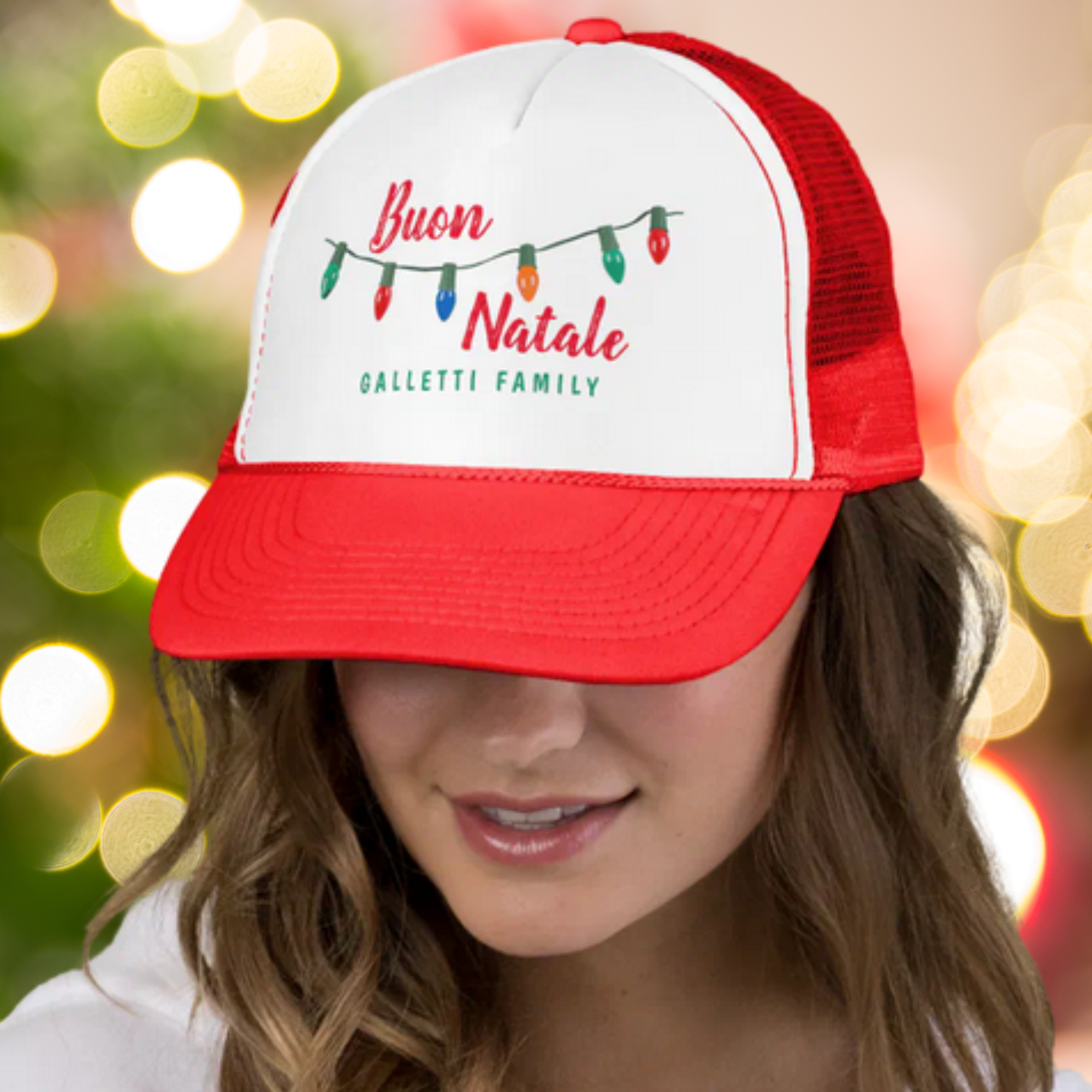 Person wearing a red and white cap with Italian Christmas-themed personalized text and lights against a blurred festive background