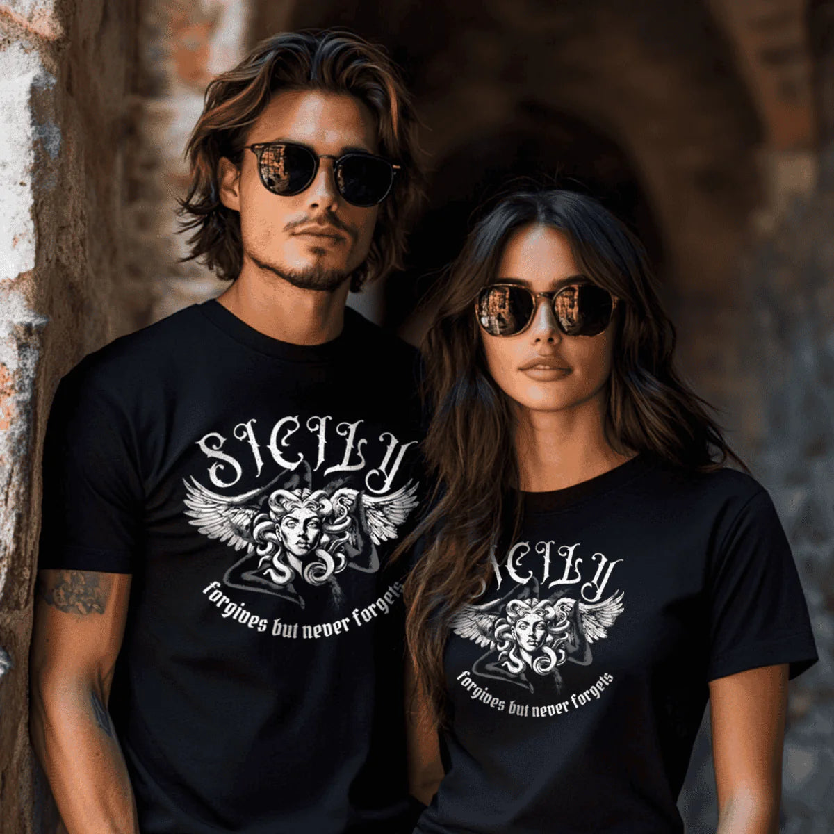 Two people wearing black t-shirts with 'Sicily' design against a textured wall.