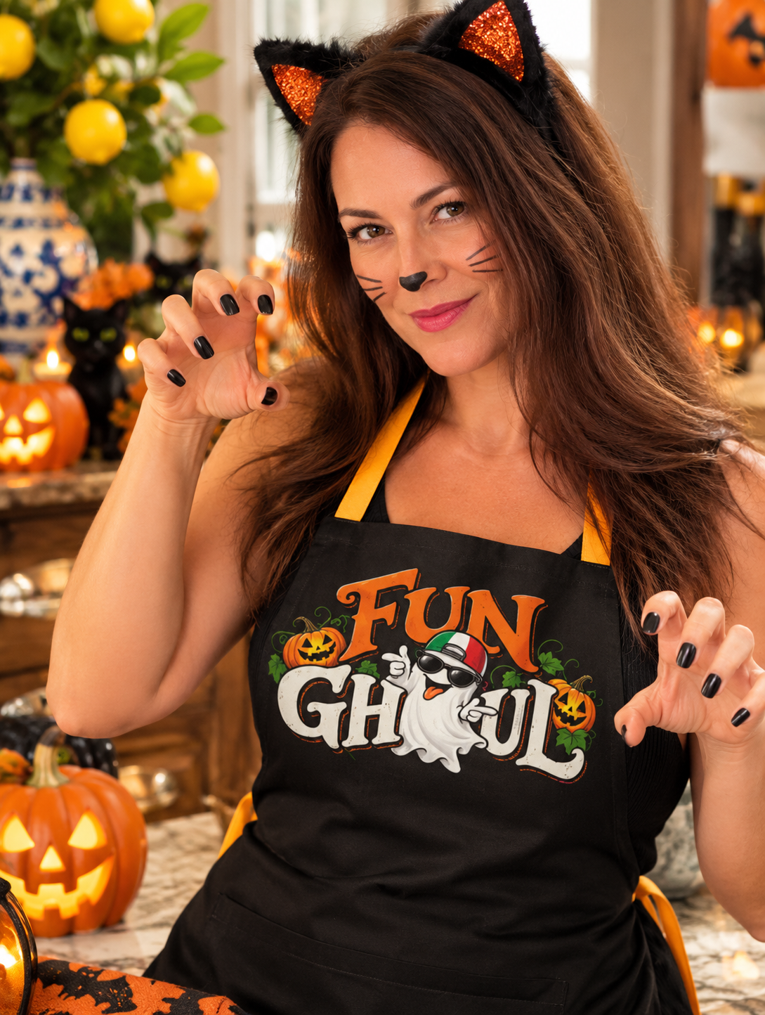 Woman wearing black Fun Ghoul Halloween apron with Italian ghost and pumpkin design, cat ears and whiskers. Fun Halloween cooking gift.