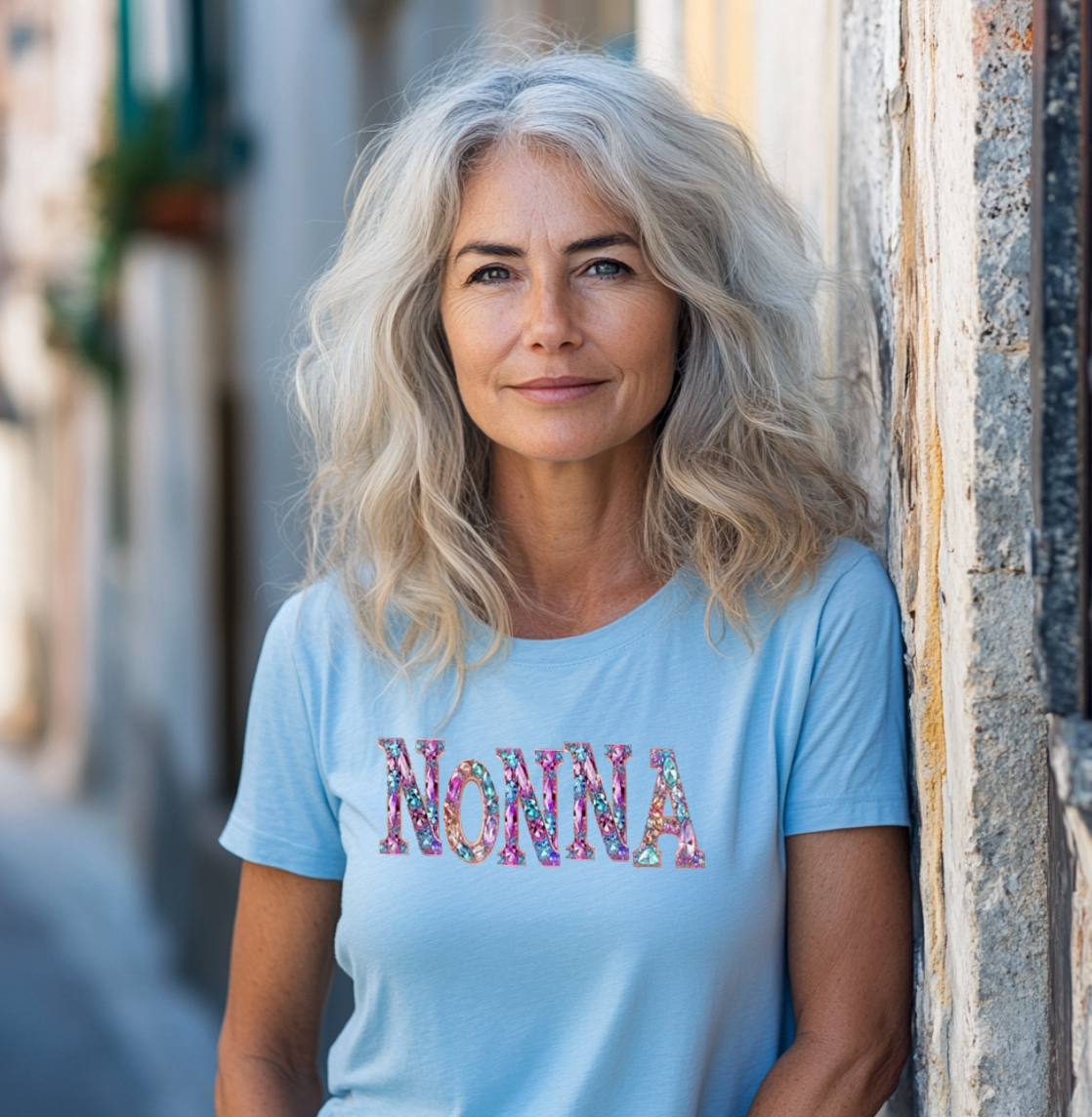 Woman wearing light blue Nonna t-shirt against stone wall - Italian grandmother gift apparel.
