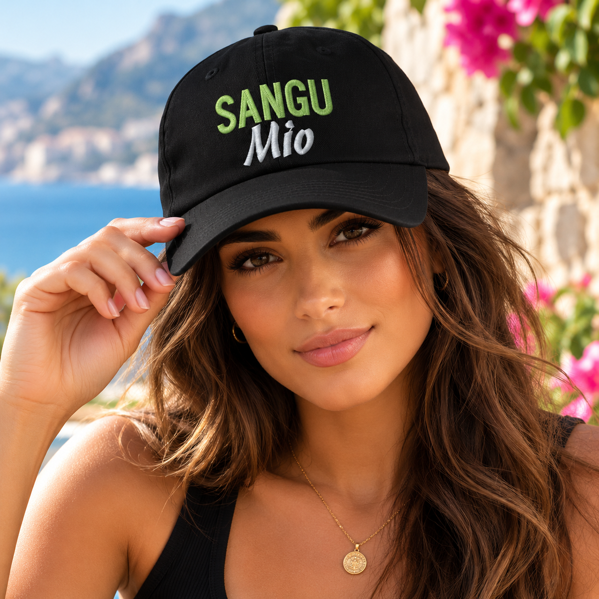 Beautiful young Italian woman wearing a black Sangu Mio embroidered baseball cap with green and silver lettering. Stylish Sicilian heritage hat celebrating family pride.