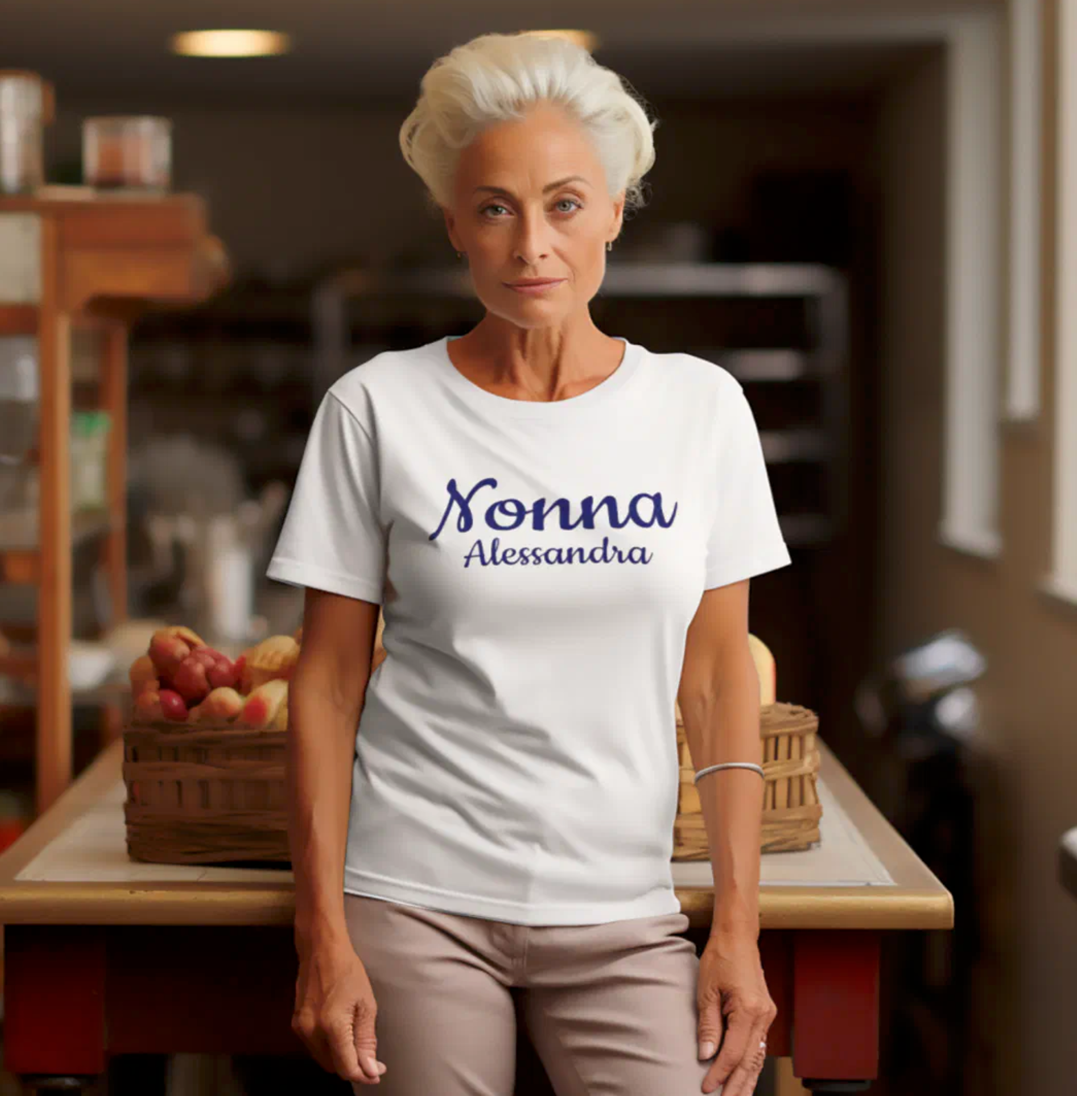 Woman wearing a white t-shirt with 'Nonna Alessandra' text in a kitchen setting. Personalized Italian Sicilian heritage gift for grandmother, gift for her, mother's day gift, Christmas gift, birthday gift.