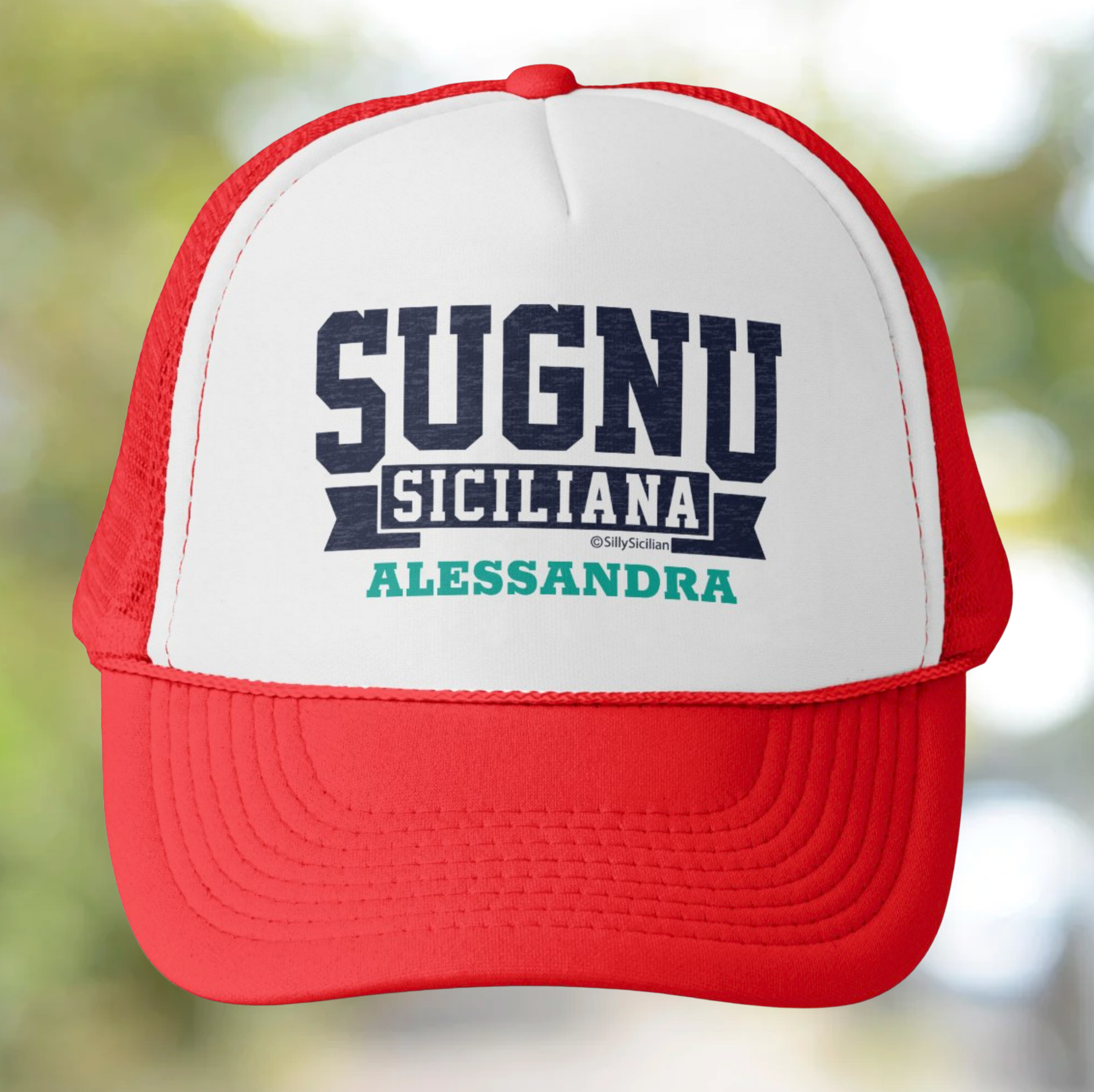 Red and white cap with 'SUGNU SICILIANA ALESSANDRA' personalized text on a blurred natural background