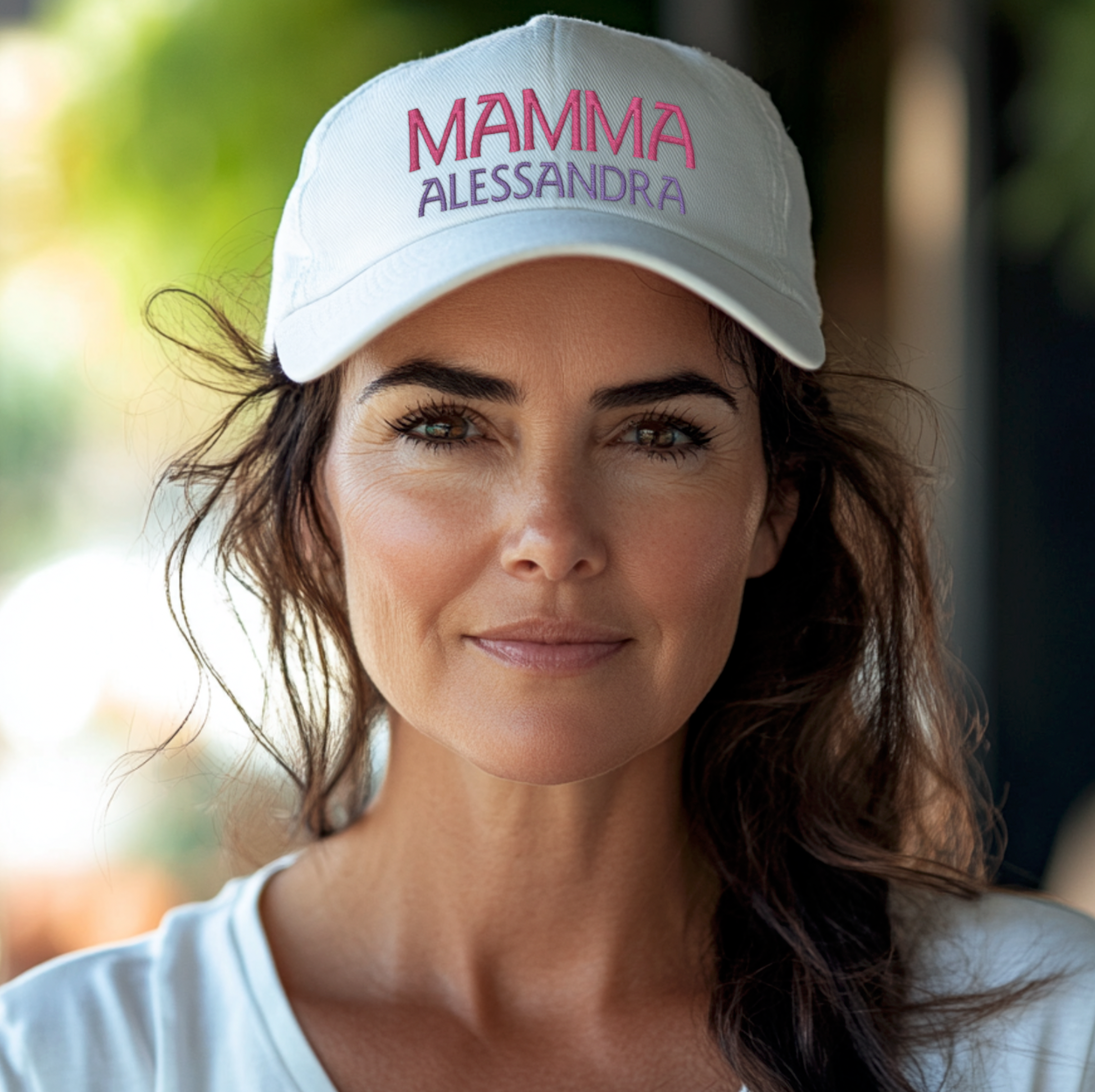 Woman wearing a white cap with 'MAMMA ALESSANDRA' text outdoors
