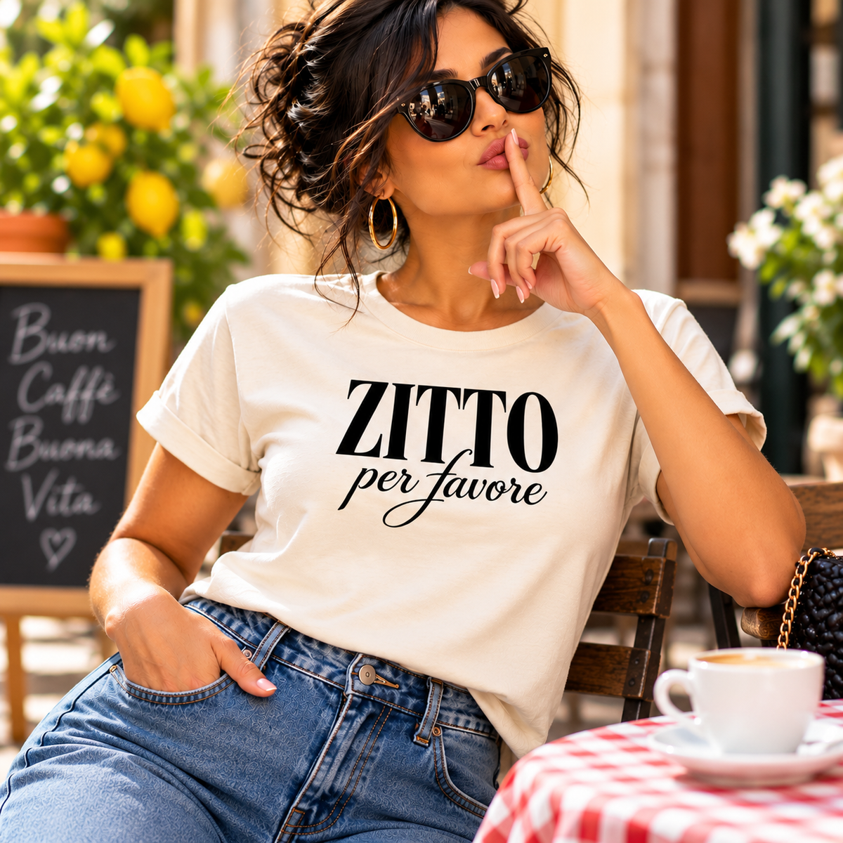 Stylish woman wearing a Zitto Per Favore Italian T-shirt, meaning “Be Quiet Please,” making a playful shushing gesture at an Italian café. Funny Italian saying shirt with bold attitude, perfect for Italian heritage lovers and humorous gifts.