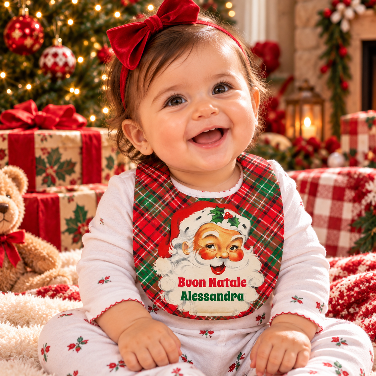 Smiling Italian baby girl wearing a personalized Buon Natale Christmas bib with vintage Santa, red and green plaid, and the name Alessandra.