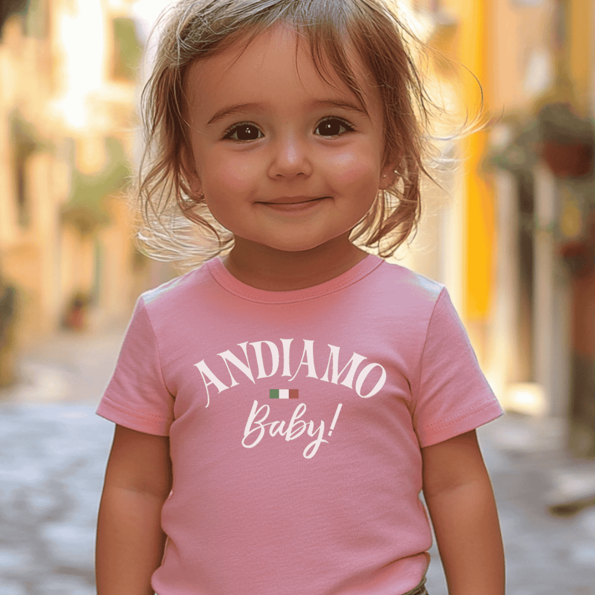 Child wearing a pink t-shirt with 'ANDIAMO Baby!' text and Italian flag - heritage gift for travel lovers