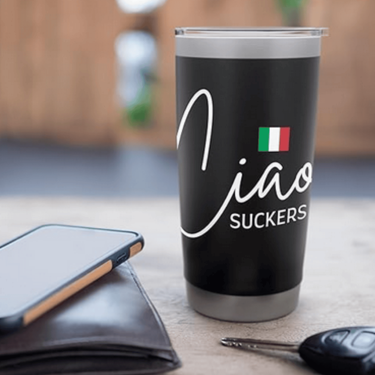 Black tumbler with 'Ciao Suckers' text and Italian flag on a table with phone and keys. Funny Italian heritage gift