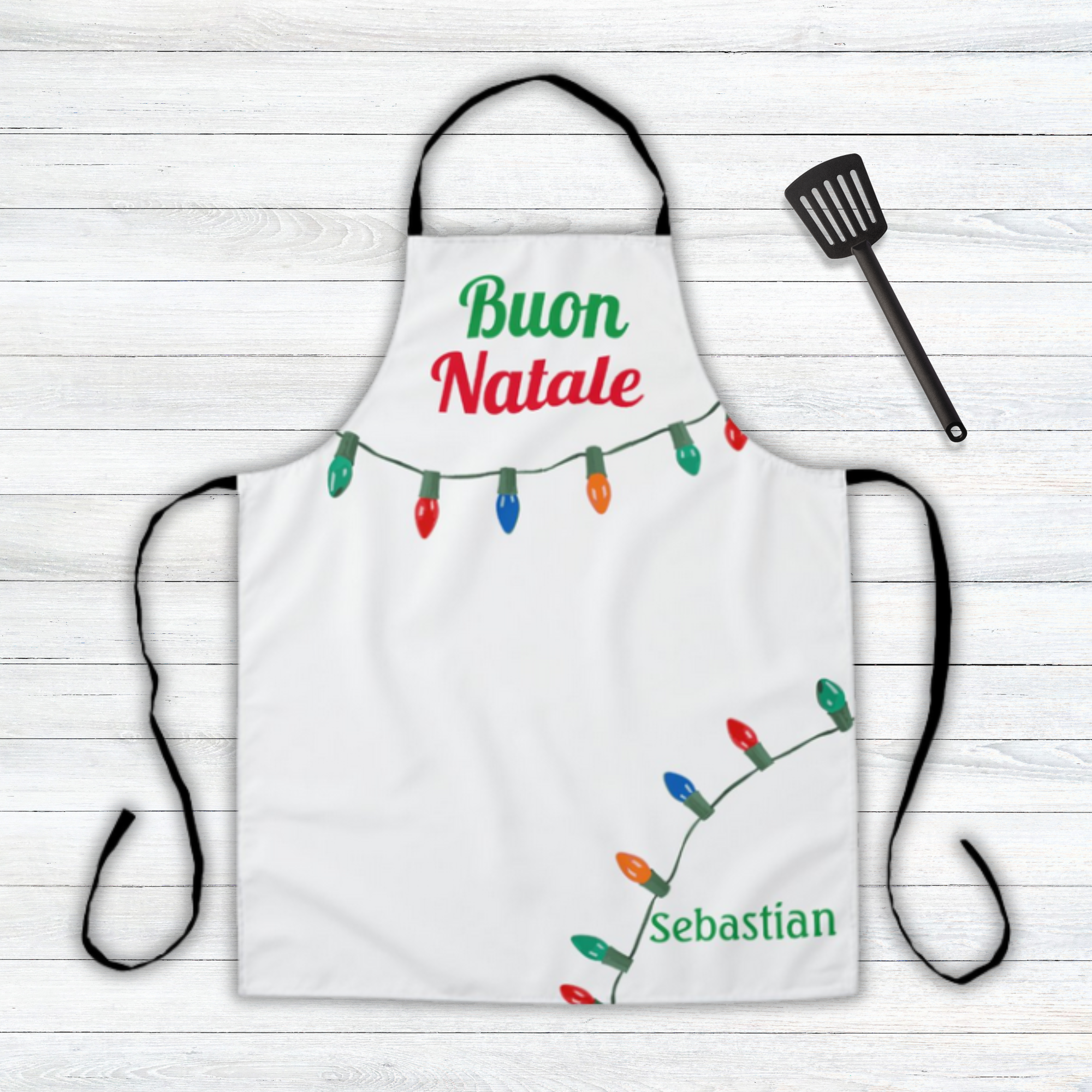 White apron with Christmas lights and 'Buon Natale' personalized text on a wooden surface
