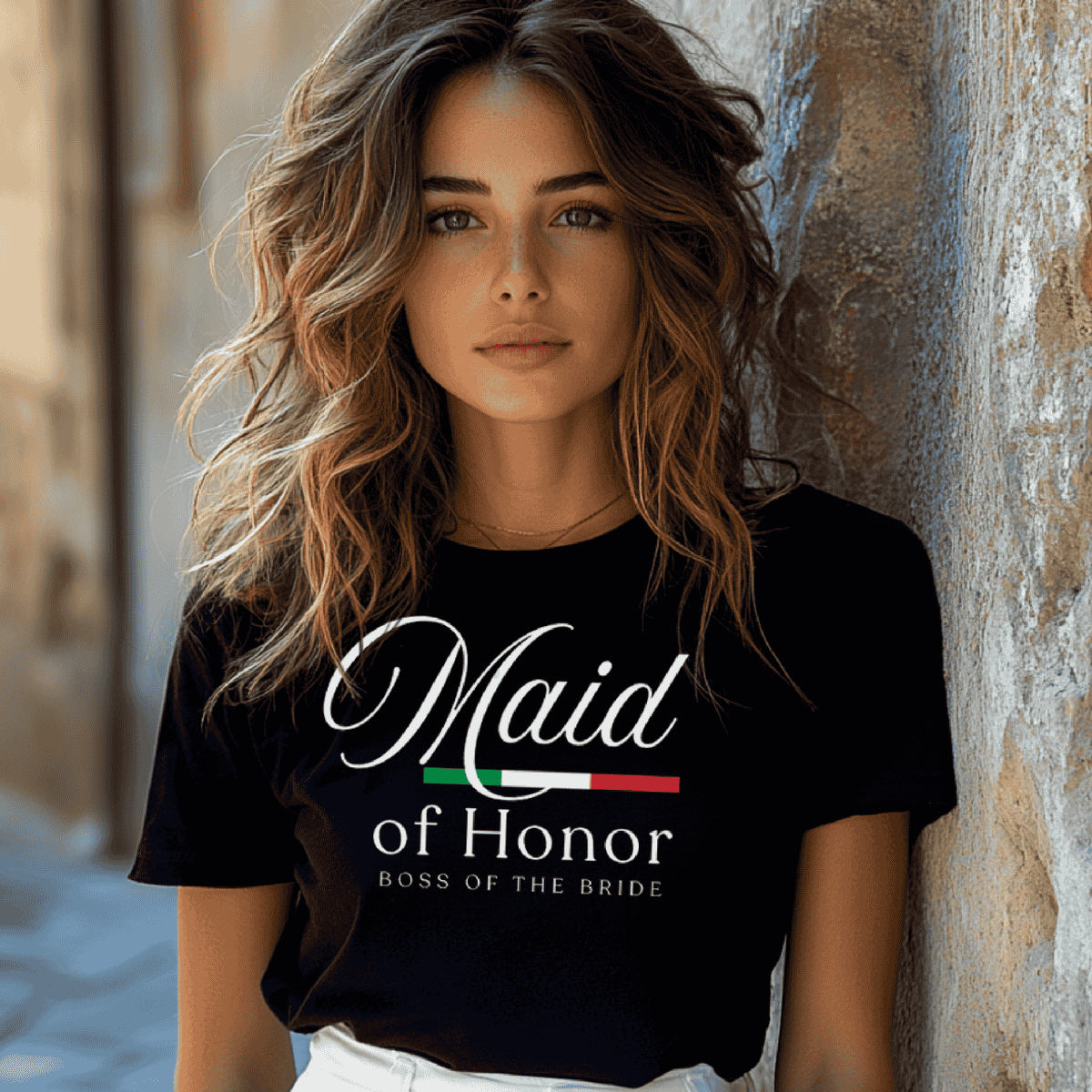 Woman wearing a black t-shirt with 'Maid of Honor Boss of the Bride' text. From a matching bridal party t-shirt collection for the whole family.