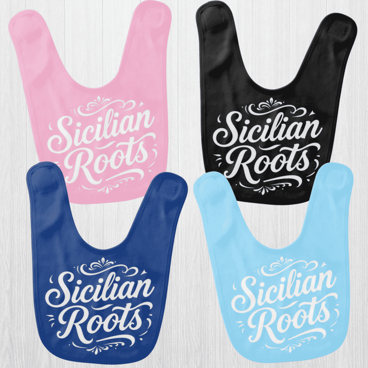 Four bibs with 'Sicilian Roots' text in different colors : pink, blue, royal and black for heritage baby gift