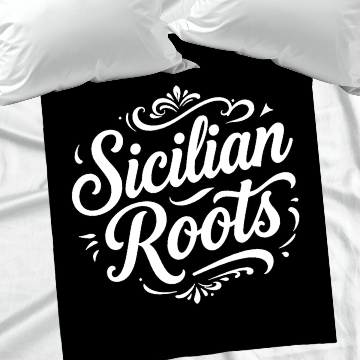 Black fleece blanket with 'Sicilian Roots' text on a white bed